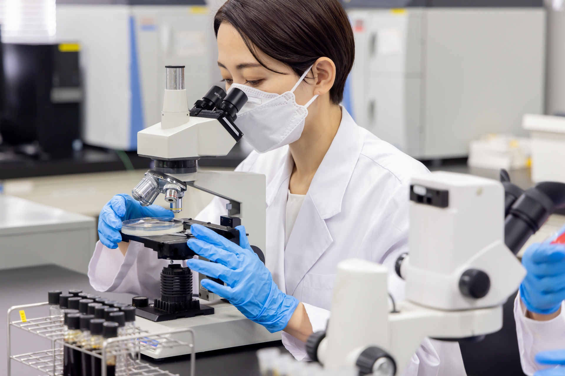 顕微鏡をのぞく研究員